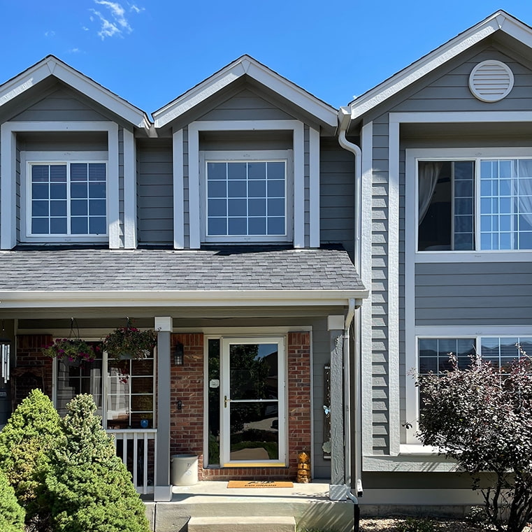 White windows with traditional grille patterns before hailstorm damage.