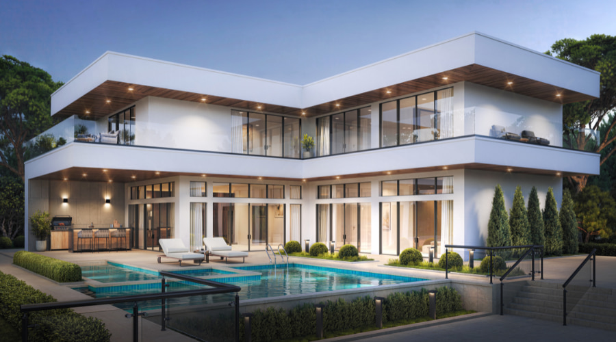 An ultra modern home that has floor-to-ceiling aluminum windows surrounds a back pool and deck furniture.