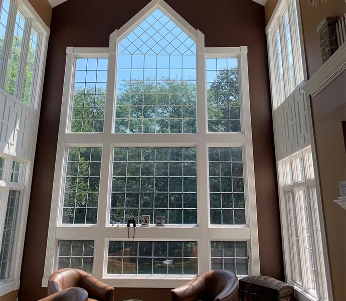 vaulted ceilings showcase a large custom wood window with custom grilles