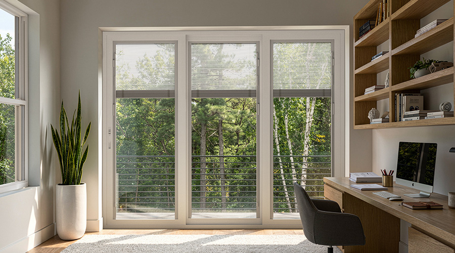 Sliding patio door in a bright home office with outdoor view.