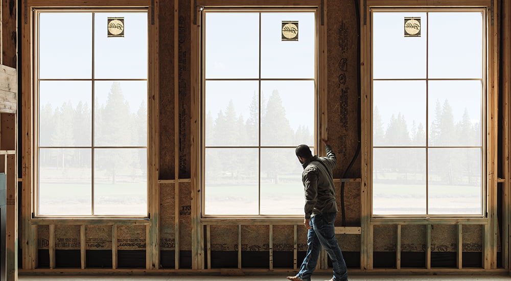 a young contractor stands in the newly installed Pella windows 