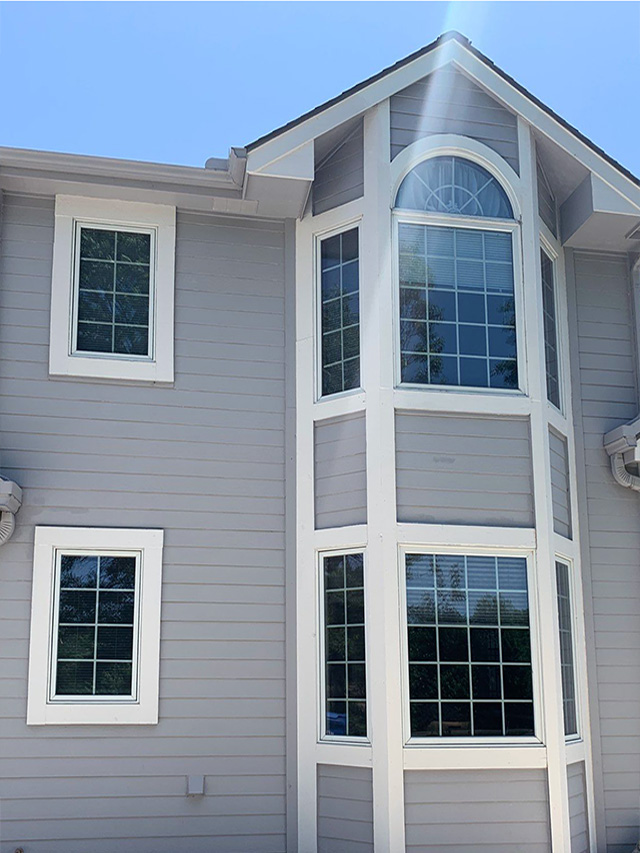 A home exterior before installation of energy efficient windows, showcasing large windows and a modern design.