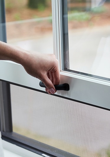 A screen is built into a white double-hung window so when you open the window the screen automatically is in place.