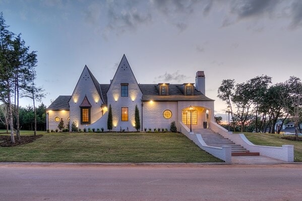 New construction home with custom shape windows lit up at dusk