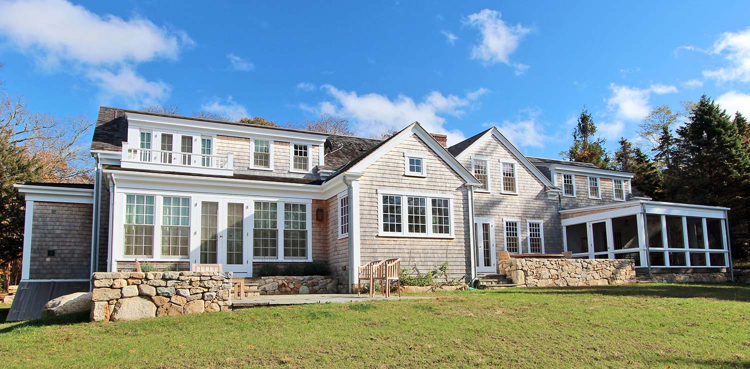 Philadelphia home with shingle siding, large windows, and a stone wall.