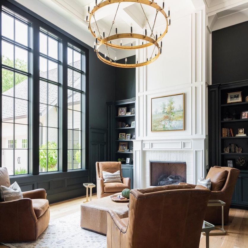 Black picture windows in a traditional-style living room add natural light to the space.