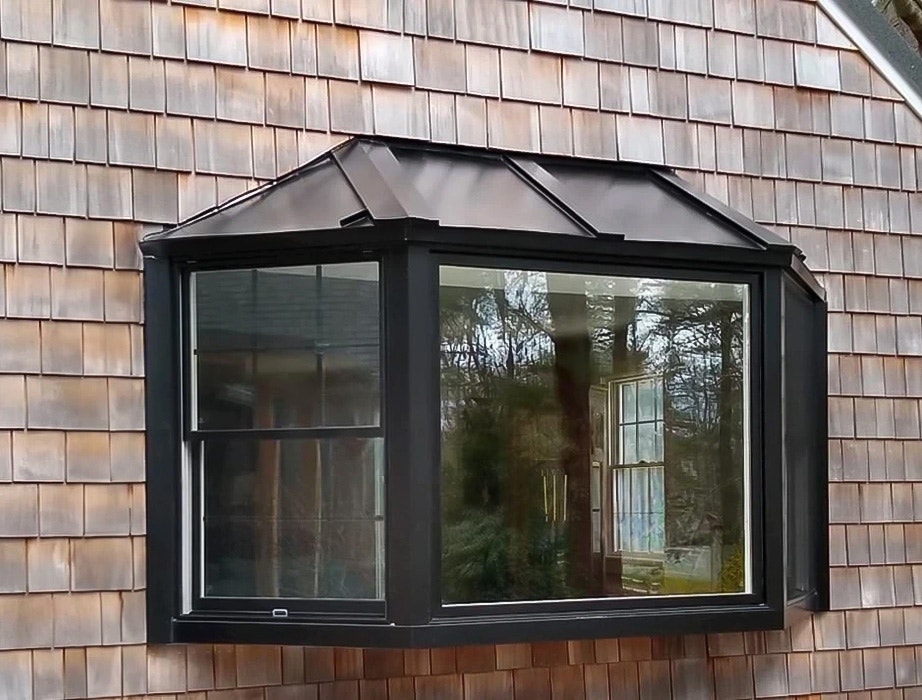 A bay window on a cedar shake home, showcasing the unique architectural design and natural materials.