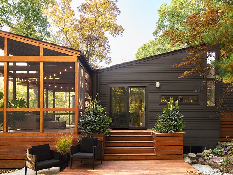 Sliding glass door in a beautiful backyard setting with a fireplace.