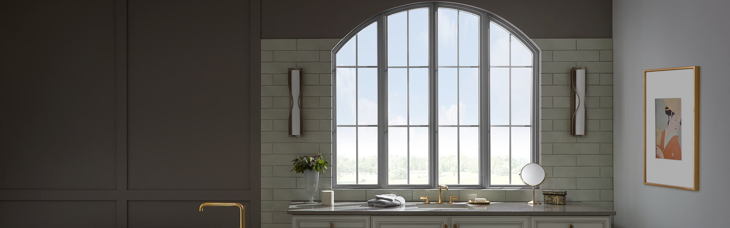 beautiful arched window over bathroom vanity with a classic soaking tub to the left of the vanity