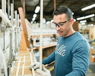 Pella manufacturing in action featuring a man working on a wood frame