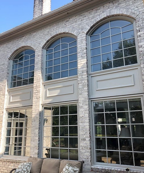six large windows on a luxurious modern brick home exterior