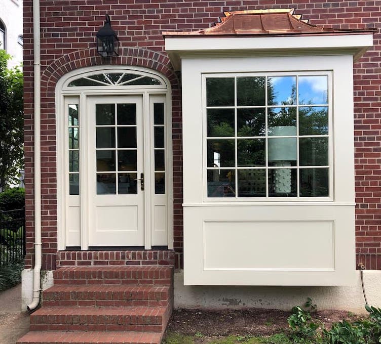 Tan picture window and custom hinged patio door with sidelights and transom on brick home