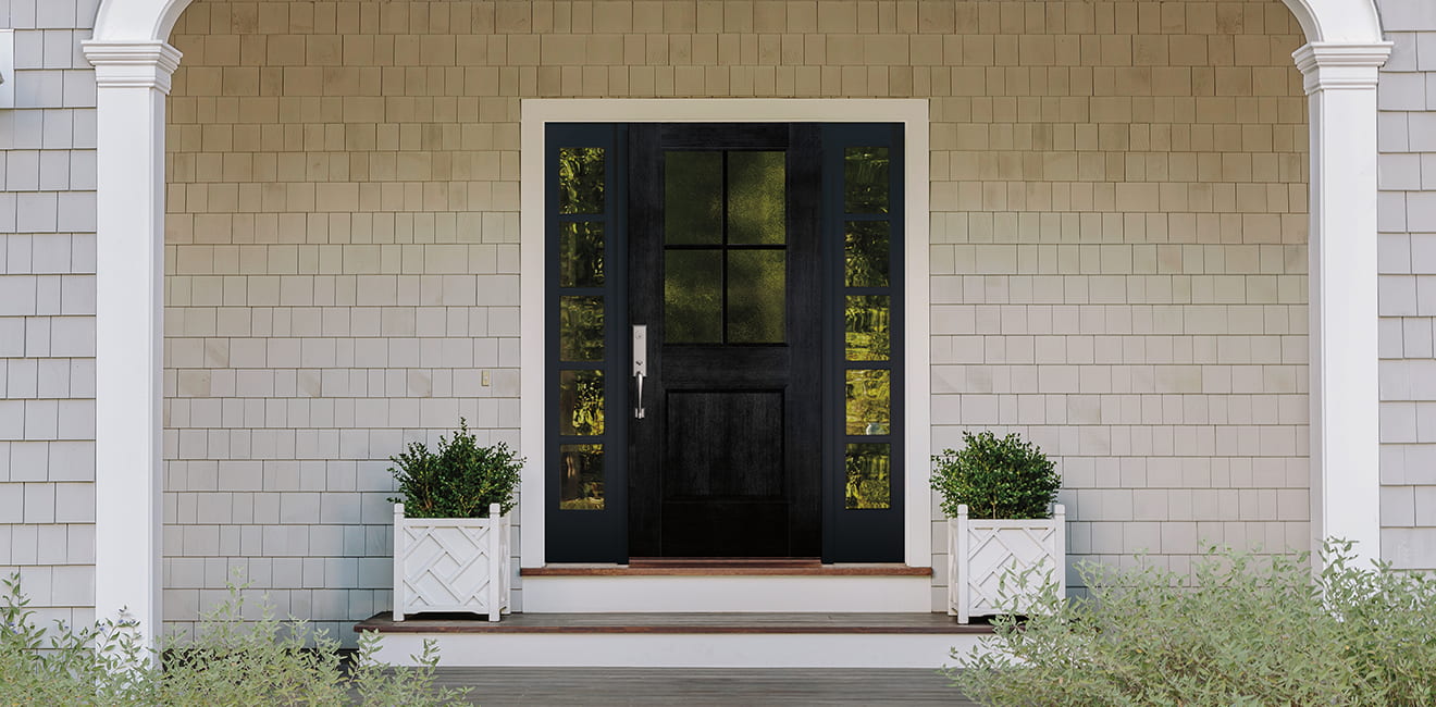 a new front entry door with potted greenery on each side