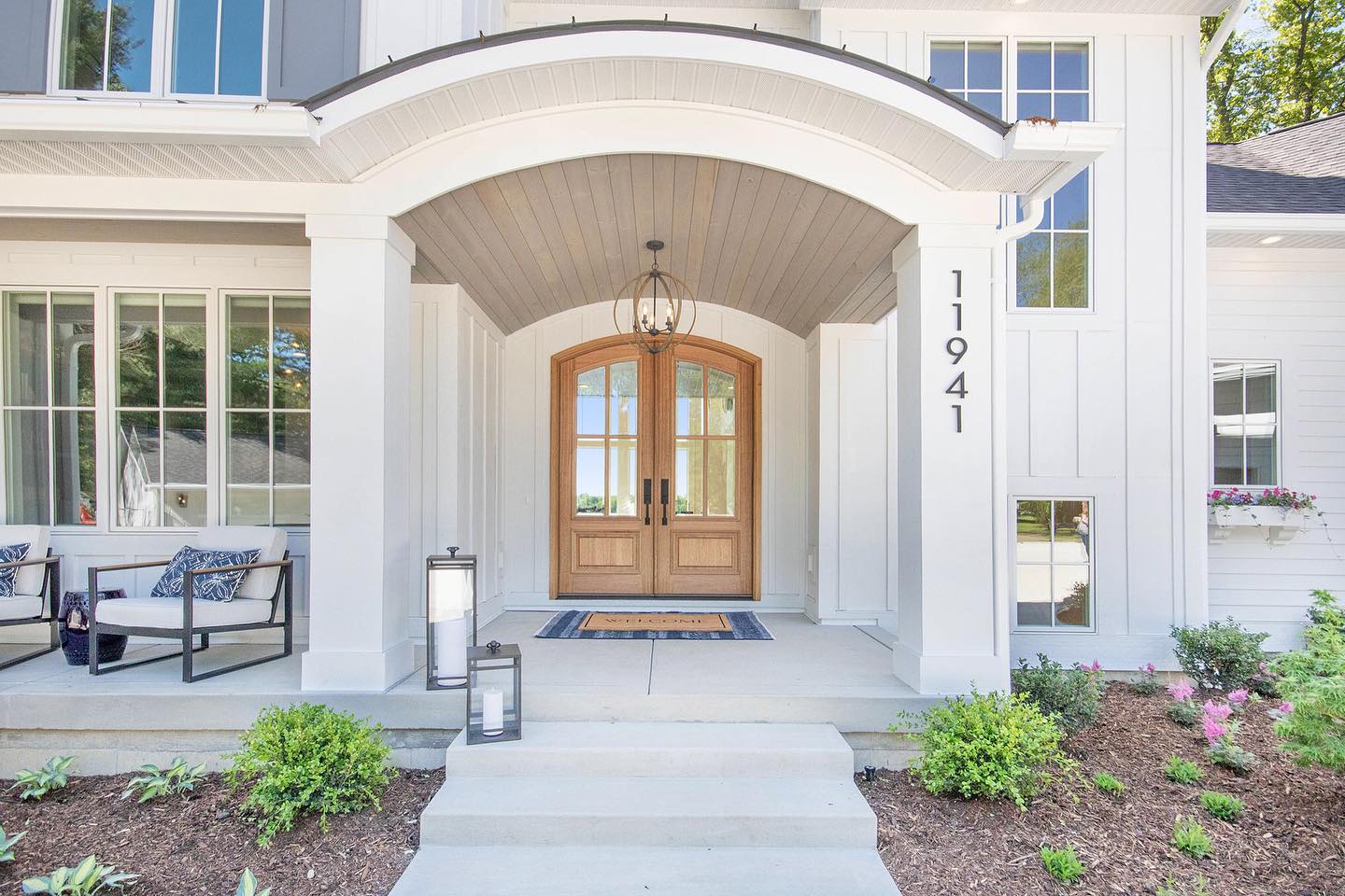 Natural wood entry doors situated under large overhang on elegant home