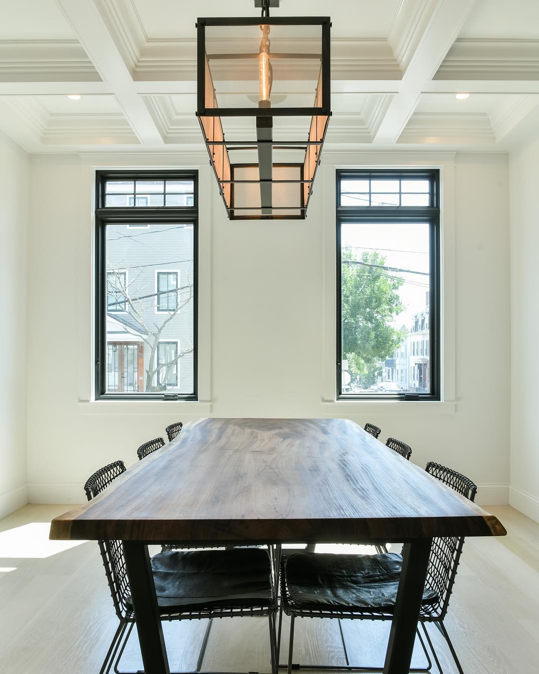Contemporary dining room brightened by two casement windows with small fixed windows overhead