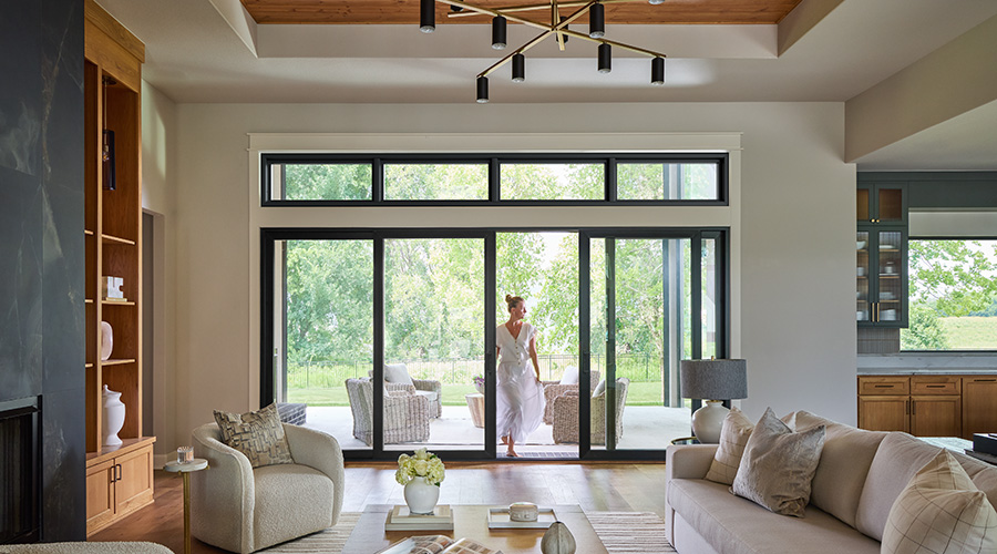 Modern living room with neutral furniture and large sliding glass doors opening to a patio.