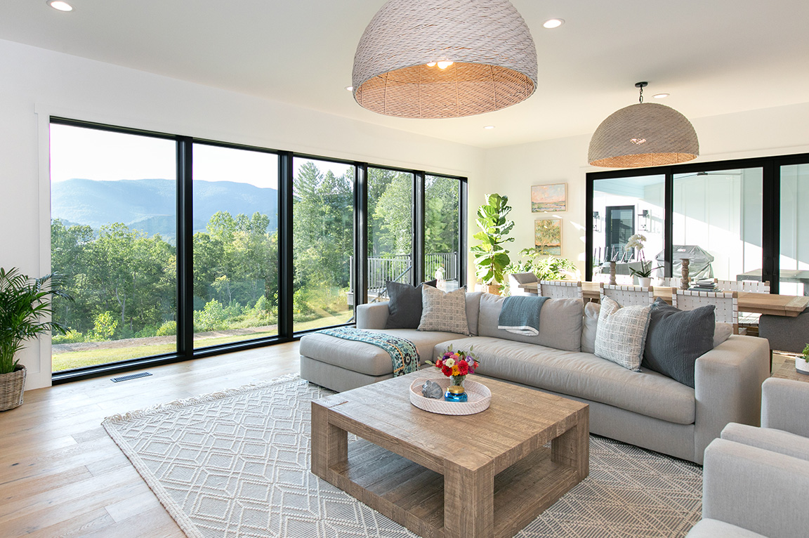Interior view of living room with a large window wall and a black sliding patio door.