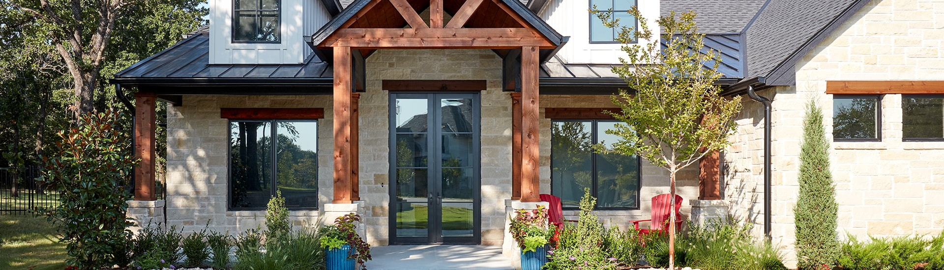 a brick home exterior with a wood-framed entryway showcase two full light wood entry doors with a rich black color