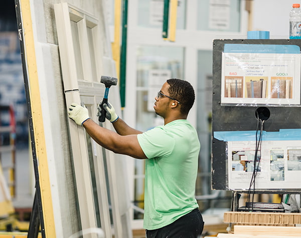 A Pella manufacturing team member is working on a custom window