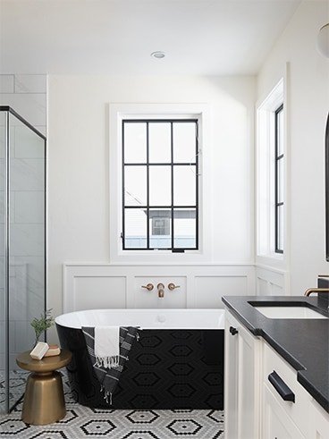 Black windows on a white wall over a black soaker tub