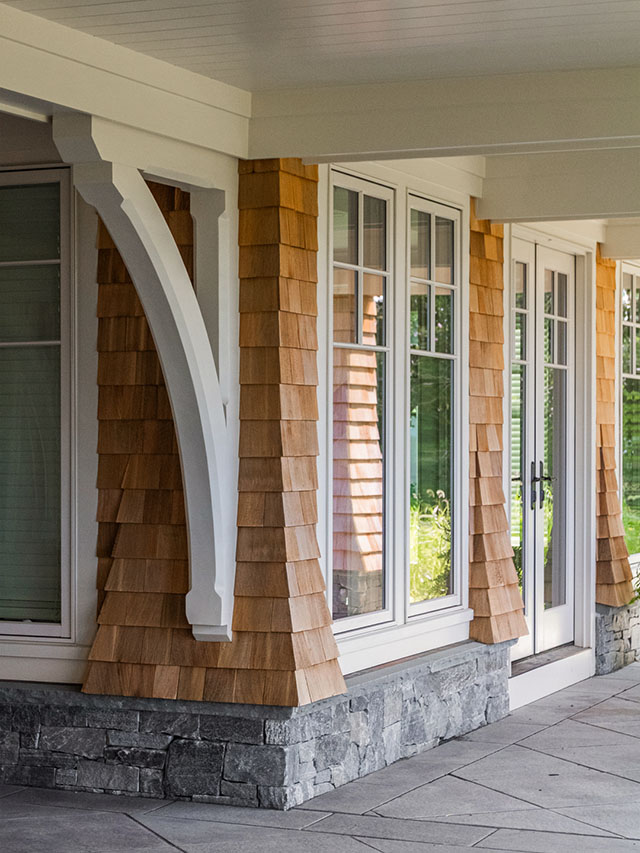 Coastal porch with white windows and cedar shingle siding.