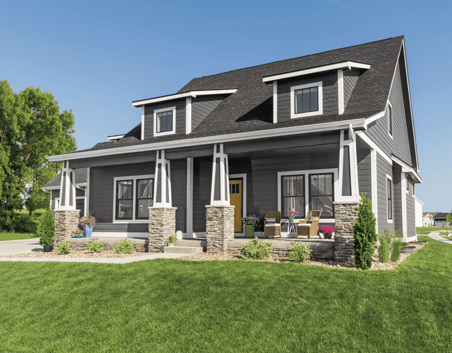 Exterior view of gray craftsman-style home with black vinyl double-hung windows.