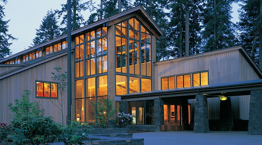 Mulled fixed windows from floor-to-ceiling on a wood and stone contemporary home.