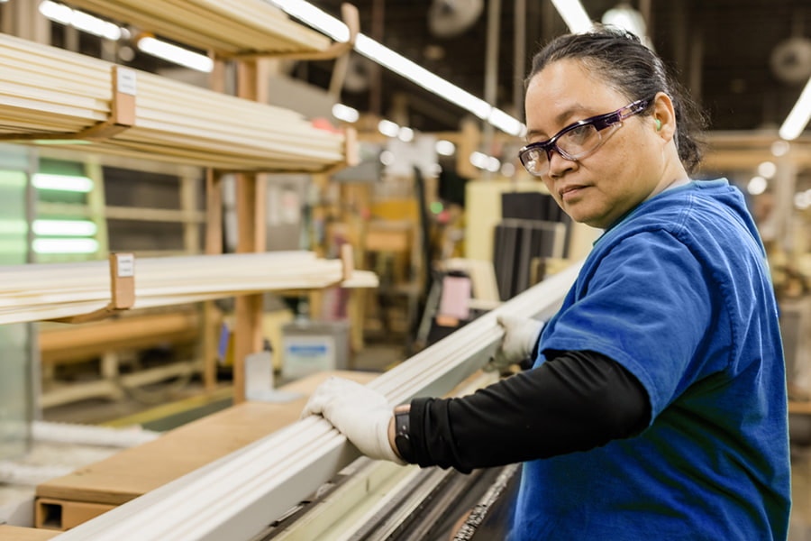 manufacturing employee using tools to assemble a window