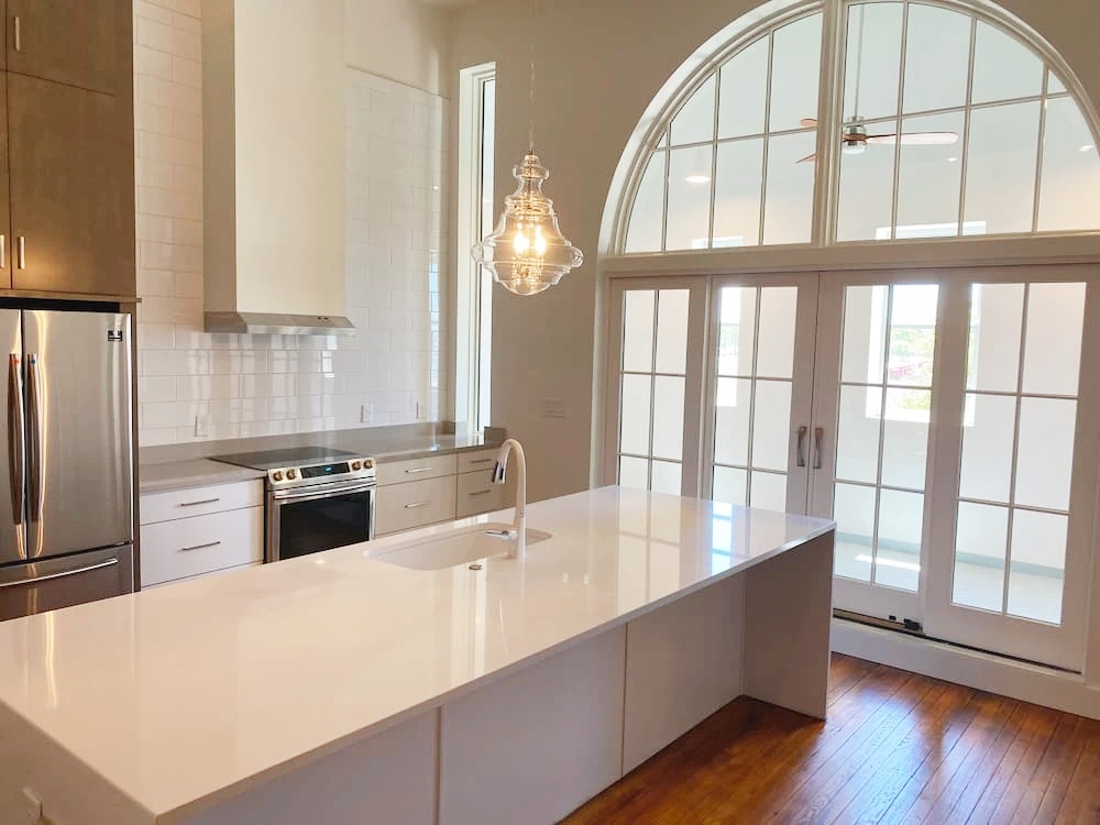 Arched doorway and sliding patio doors in Cape Charles kitchen.