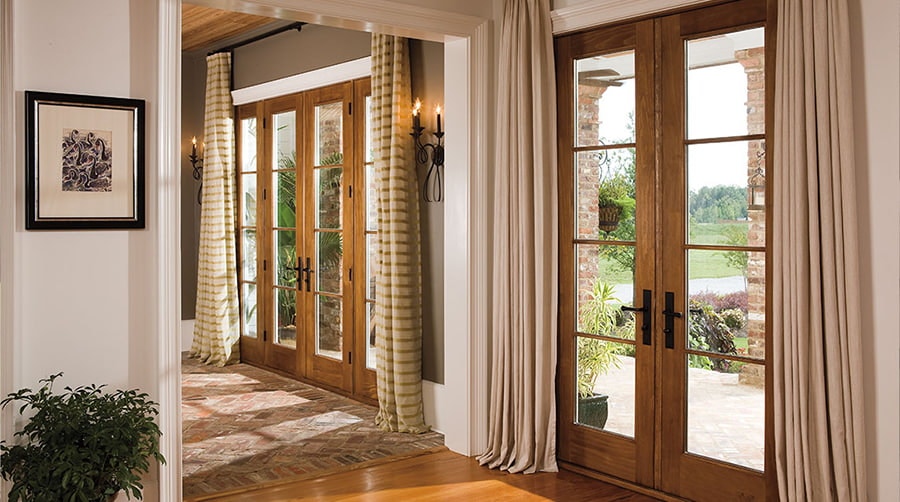 three sets of two-panel wood hinged doors with floor-to-ceiling curtains