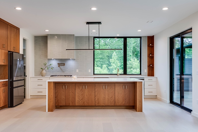 Interior view of modern kitchen with black windows over the kitchen sink.