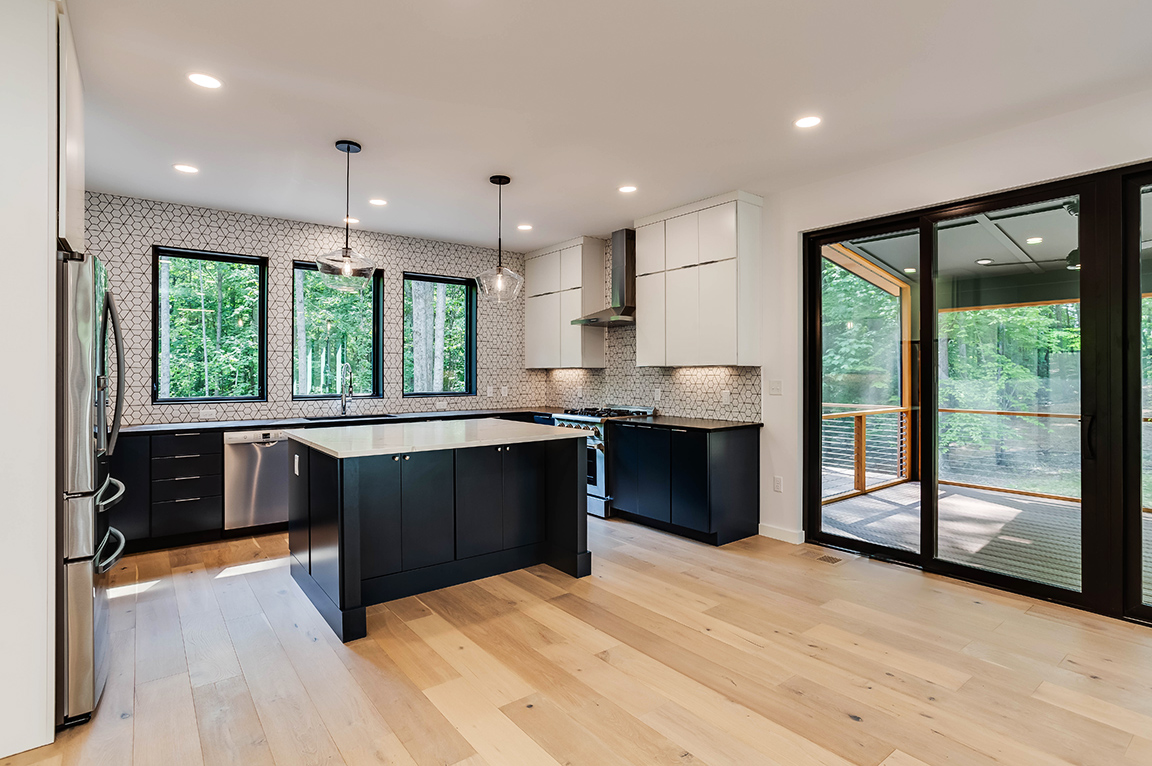 Modern kitchen with three large windows over the sink. 