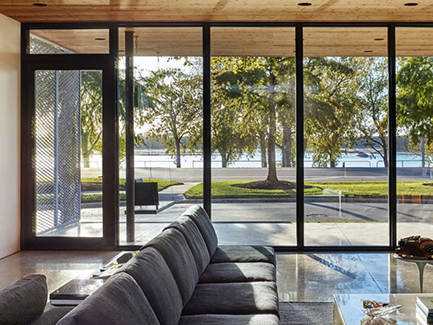 two young boys playing on white built-in beds and looking out a bright yellow round window.