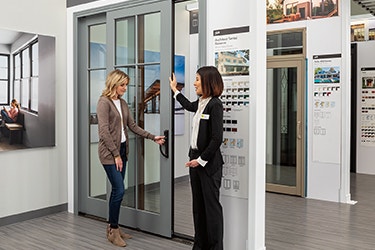 A woman is getting a demonstration on new Pella products at her local Showroom.