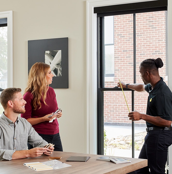 Consultation in Chicago with a professional measuring a window in a modern interior.