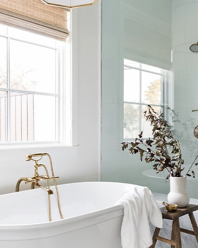 white soaker tub with brass fixtures