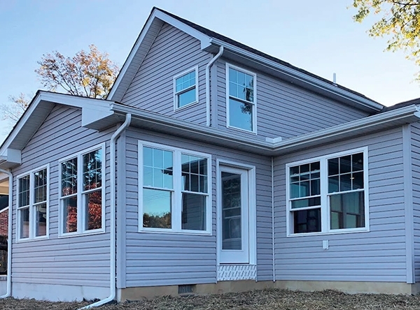 Backyard view of Stewartstown ranch-style home with newly installed white vinyl windows.