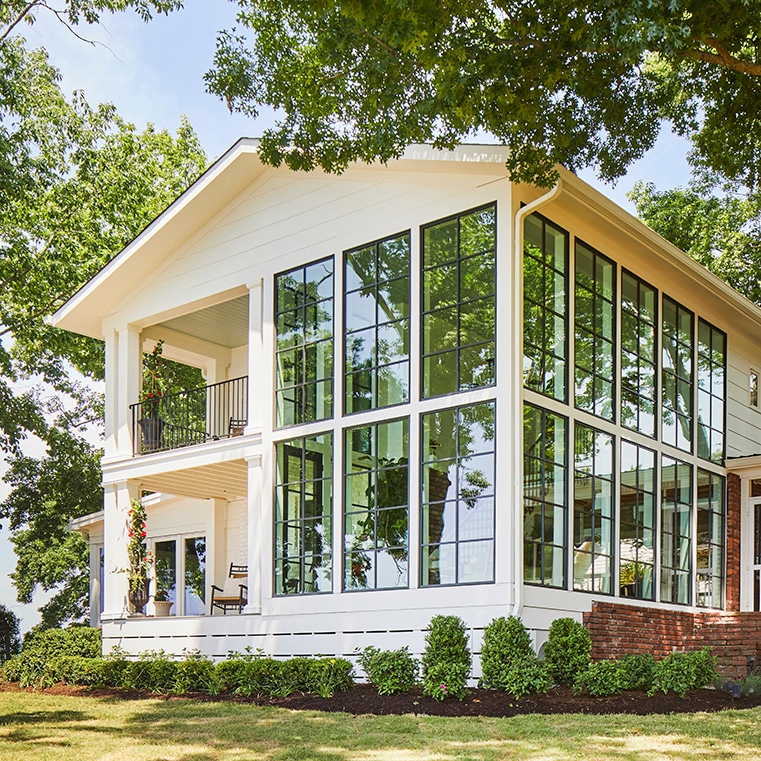 Nashville lake house featuring black window wall facing lakefront. 
