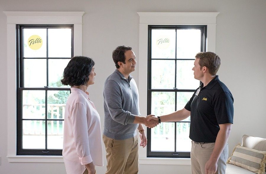 Pella consultant is shaking hands with a man in a gray shirt who stands next to his wife