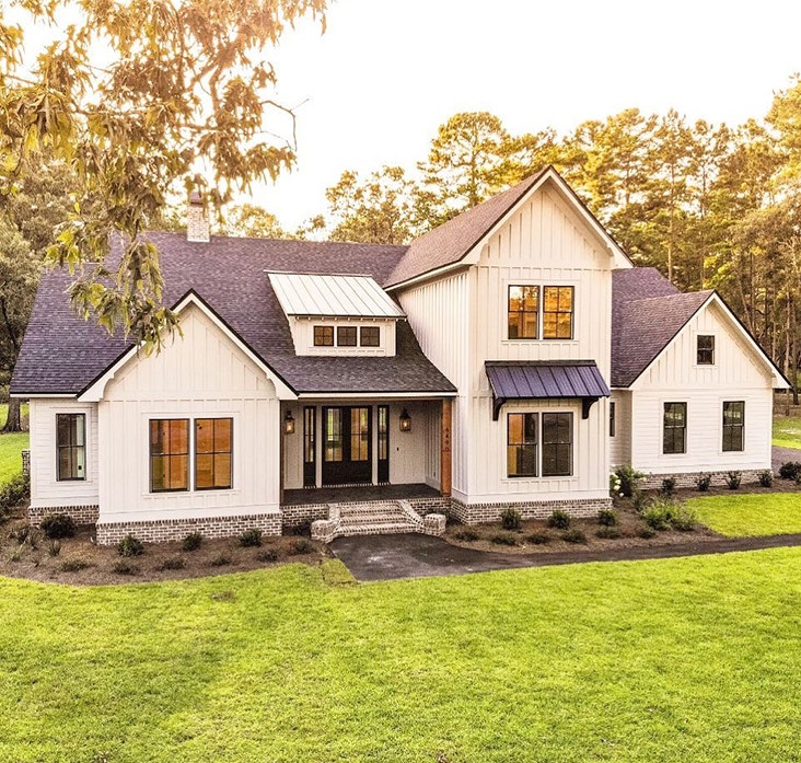 white modern farmhouse exterior with black double-hung windows and black front door