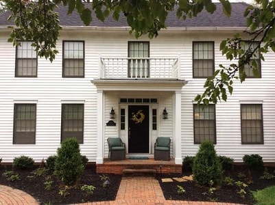 White traditional home with old black double-hung windows