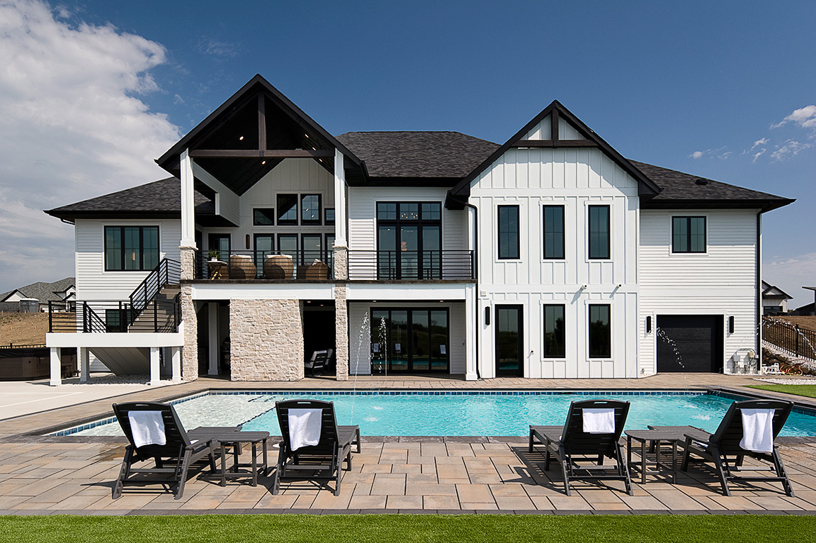 A modern home exterior with a pool, featuring new construction windows and a stylish design.