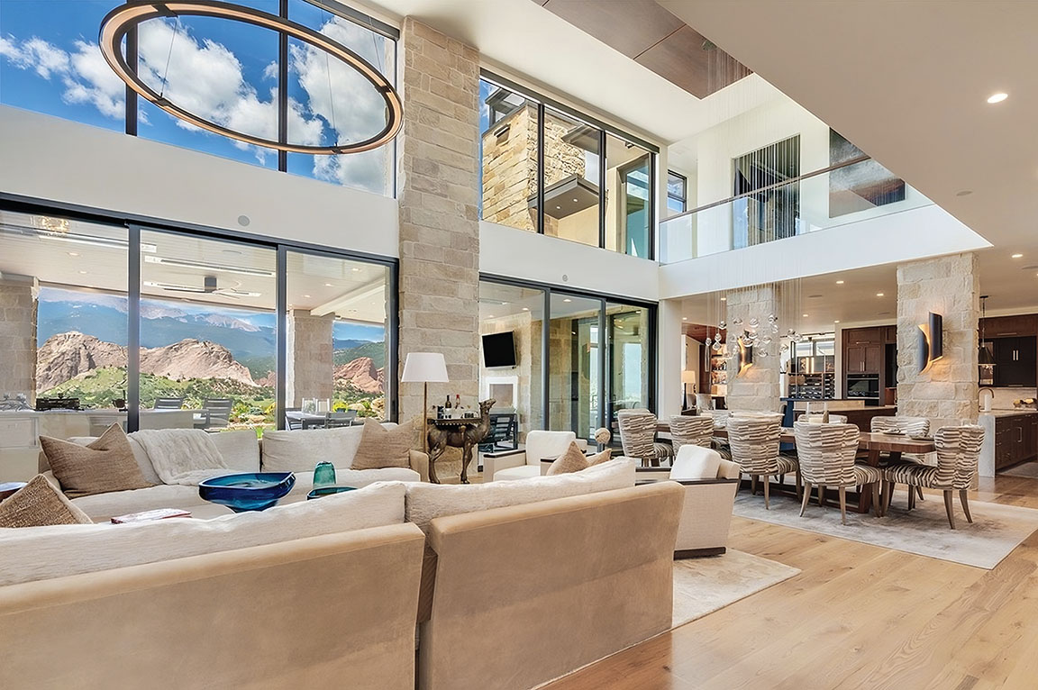 The interior of a modern house with large black modern windows that go from the floor to the ceiling.