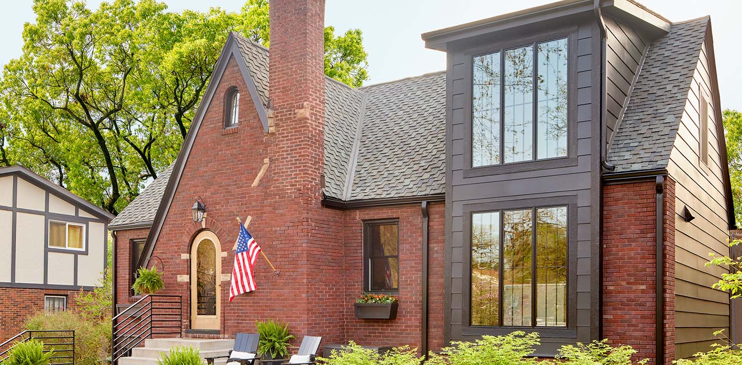 Brick house in Chicago with large vertical windows and a gabled roof.