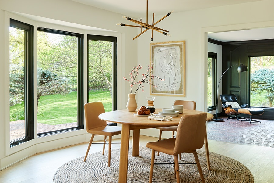 Contemporary modern dining room with three black windows in a bowed configuration.