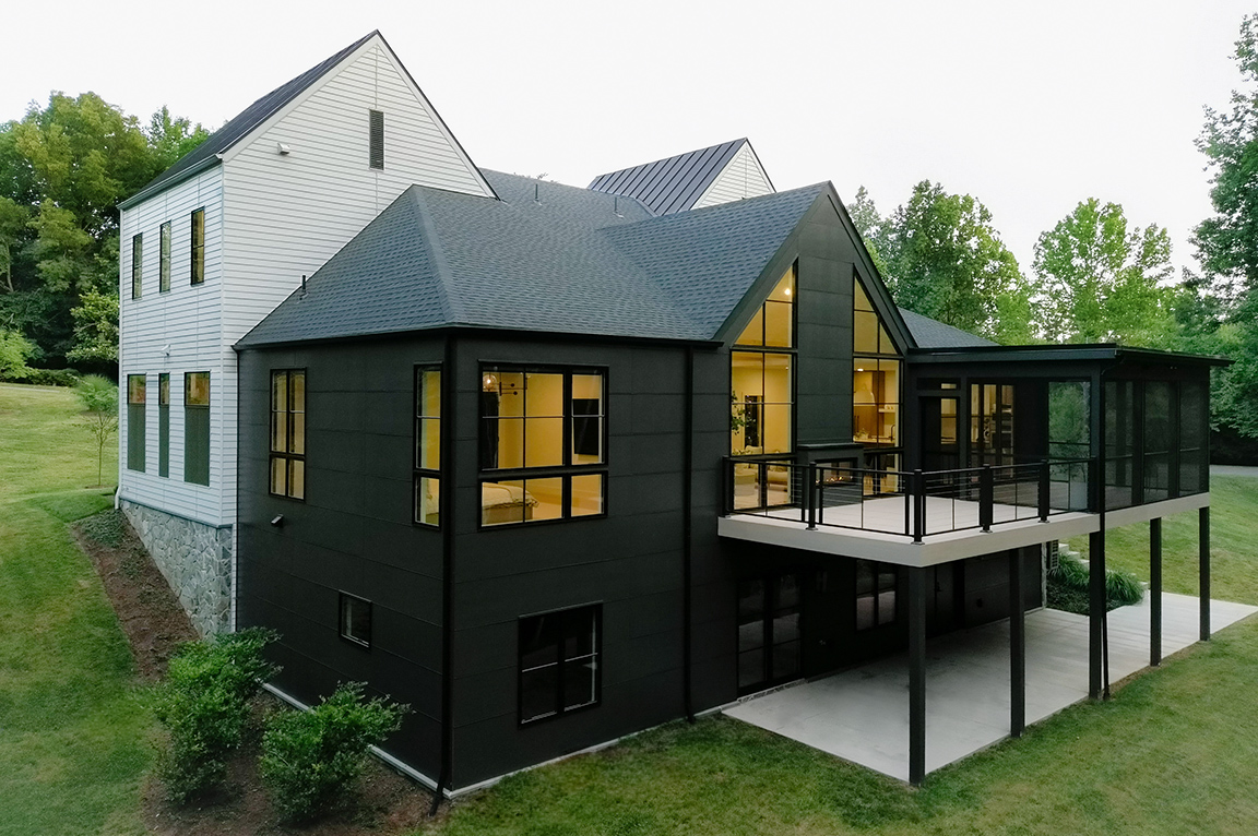 Backyard view of black and white new construction home in Charlottesville.
