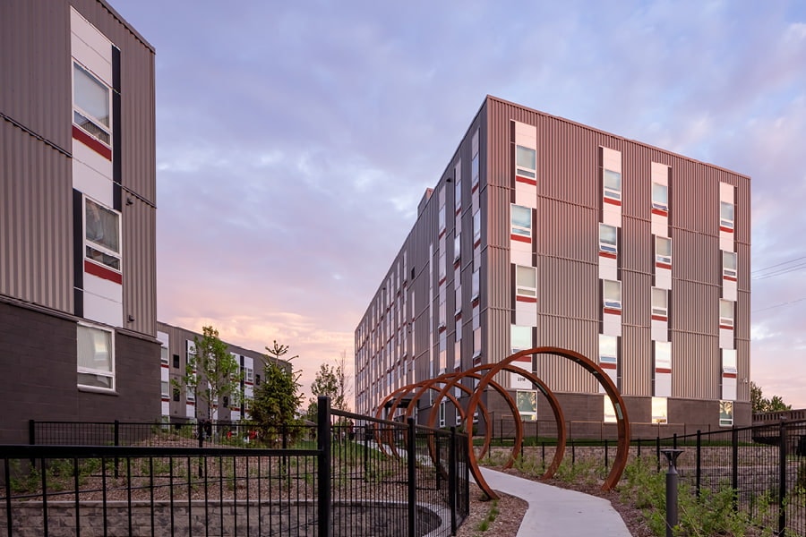 Three building with metal exterior and white picture windows and awning windows