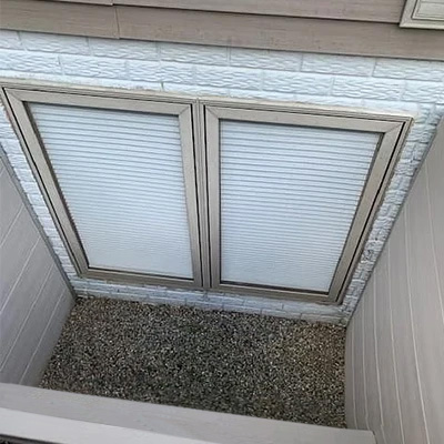 An egressed pair of Pella Impervia fiberglass casement windows with blinds-between-the-glass.