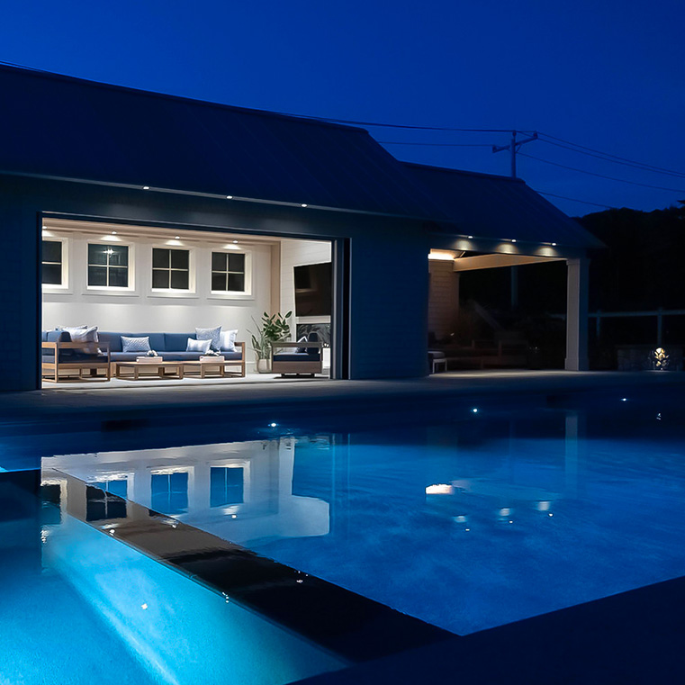 Luxury pool house with illuminated swimming pool at night