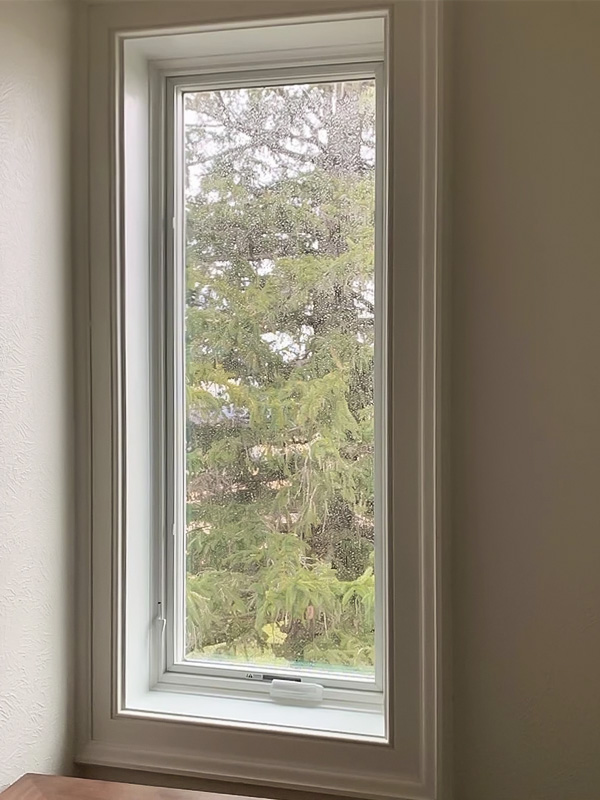 One Lifestyle Series casement window with white hardware on a beige wall.